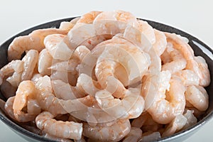 A bowl of peeled fresh raw white shrimp with tail