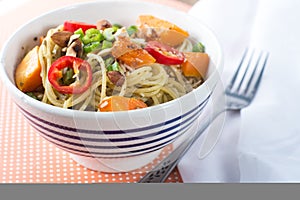 Bowl of pesto pasta with fresh vegetables