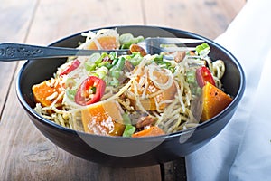 Bowl of pesto pasta with fresh vegetables