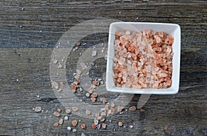 Bowl of Pink Himalayan Salt on a rustic wood plank board with room for copy space