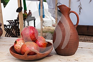 Bowl of pomegranate fruits and earthenware pitcher