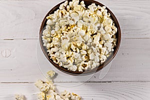 Bowl with popcorn on wooden table
