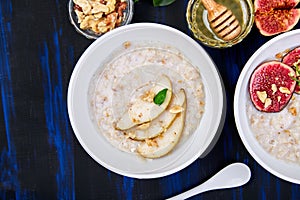 A bowl of porridge with pears slices and walnuts and porridge with figs