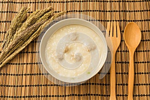 A bowl of porridge with wooden texture on background.