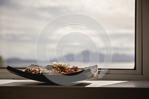 Bowl of pot pourri with landscape in the background lit by the s