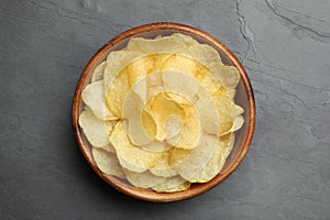 Bowl of potato chips on grey table