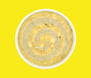 Bowl of potato leek soup on yellow background