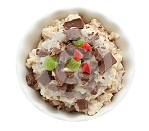 Bowl with prepared oatmeal, candied fruit and chocolate on white background