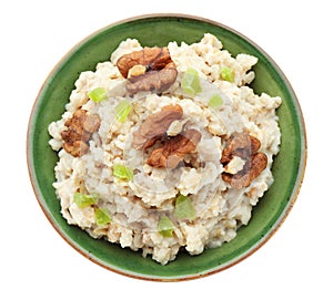 Bowl with prepared oatmeal, candied fruit and walnuts on white background
