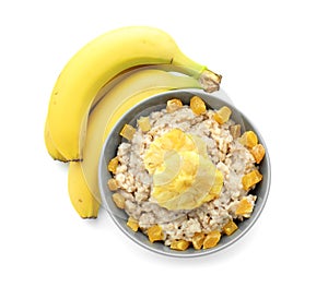 Bowl with prepared oatmeal, dried pineapple and bananas on white background