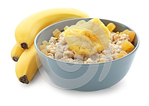 Bowl with prepared oatmeal, dried pineapple and bananas on white background