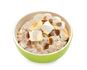 Bowl with prepared oatmeal, raisins and banana on white background