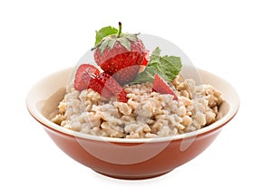 Bowl with prepared oatmeal and strawberry on white background