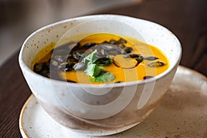 Bowl of pumpkin soup with grilled seeds and coriander toppings, Belgium