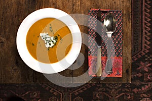 Bowl of pumpkin soup on a wooden table