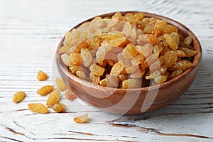 Bowl with raisins on wooden table. Dried fruit