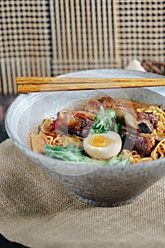 A bowl of ramen with meat and egg in it