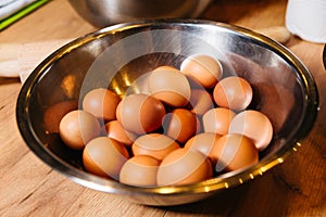 Bowl of Raw Brown Eggs on Wooden Kitchen Table