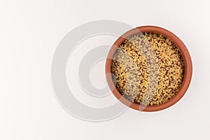 Bowl of raw bulgur and quinoa isolated on white background