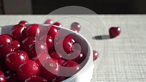 Bowl With Red Fresh Ripe Cherries On The Background Of A White Brick Wall