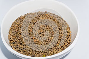 A bowl of red lentils shot in studio settings. In India it is also called black masoor dal