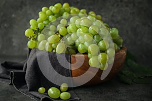 Bowl with ripe juicy grapes on grey table