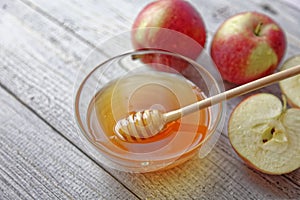 Bowl rustic honey and apples on wooden table. Traditional celebration food for the Jewish New Year. Concept Rosh Hashana