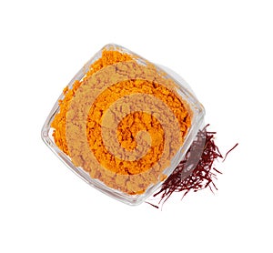 Bowl with saffron powder and dried flower stigmas on white background, top view