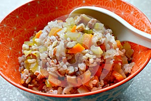 A bowl of savory vegetable congee or rice porridge, made with brown rice, shitake mushrooms, chopped celery and carrots