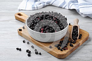 Bowl and scoop with dried blueberries on white wooden table