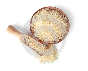Bowl and scoop with uncooked parboiled rice on white background