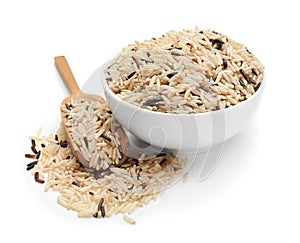 Bowl and scoop with unpolished rice on white background