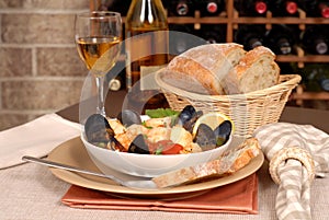 Bowl of seafood soup with wine and rustic bread