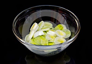 Bowl with sliced leek on black