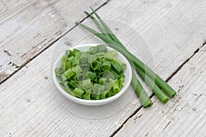 bowl with sliced ??spring onions on a light wooden background