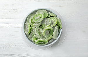 Bowl with slices of kiwi on wooden background. Dried fruit as healthy food