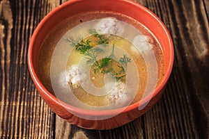 A bowl soup with meatbolls