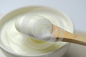 Bowl of sour cream yogurt with wooden spoon