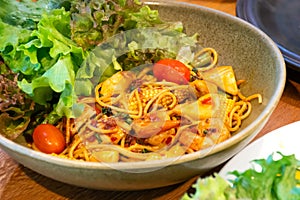 A bowl of spaghetti noodles with shrimp squid and tomatoes