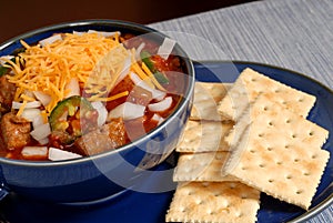 Bowl of spicey chili with crackers