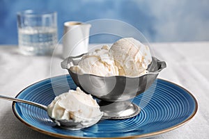 Bowl and spoon with tasty vanilla ice cream