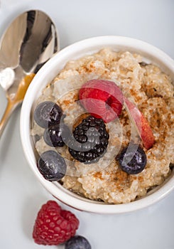 Bowl of steel cut oats served with fresh fruit and honey