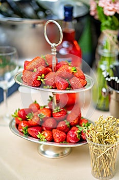 Bowl of strawberries on holiday table catering. delicious sweet treats outdoors