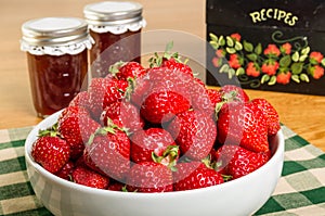 Bowl of strawberries and jars of jam