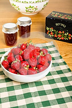 Bowl of strawberries and jars of jam