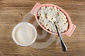 Bowl with sugar, spoon in pink bowl with cottage cheese on wooden table. Top view