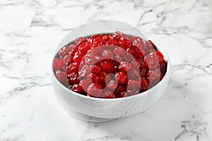 Bowl of sweet cherries on marble background.