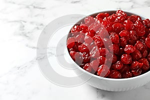 Bowl of sweet cherries on marble background, space for text. Dried fruit