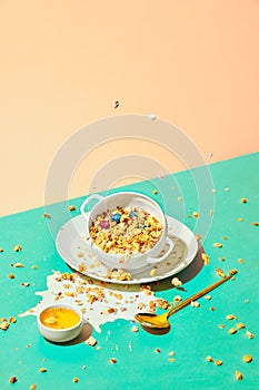 Bowl with sweet muesli, cereal with berries and milk against pastel background. Breakfast time