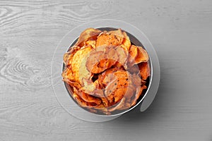 Bowl of sweet potato chips on grey table